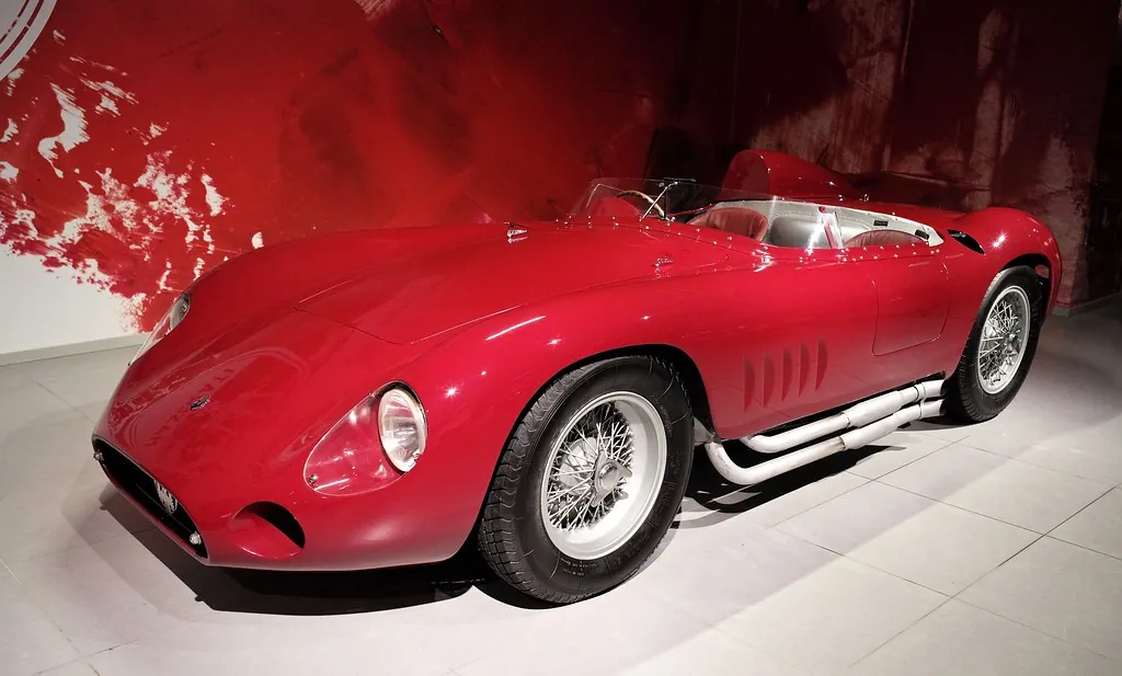 Un auto de carreras vintage exhibido contra un muro de galería dramático