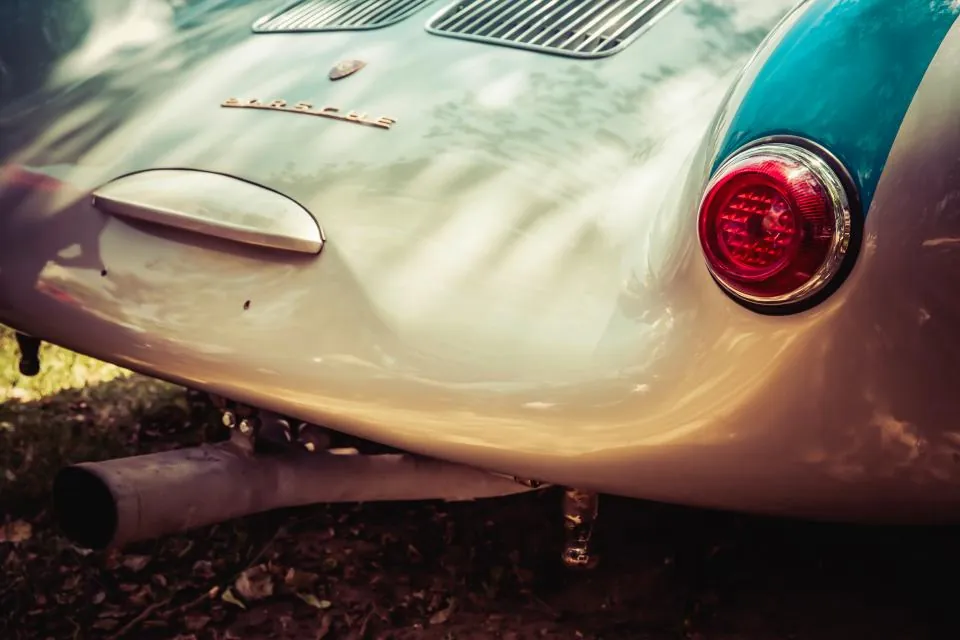 Detail of a Porsche 356 rear light and badge in golden light