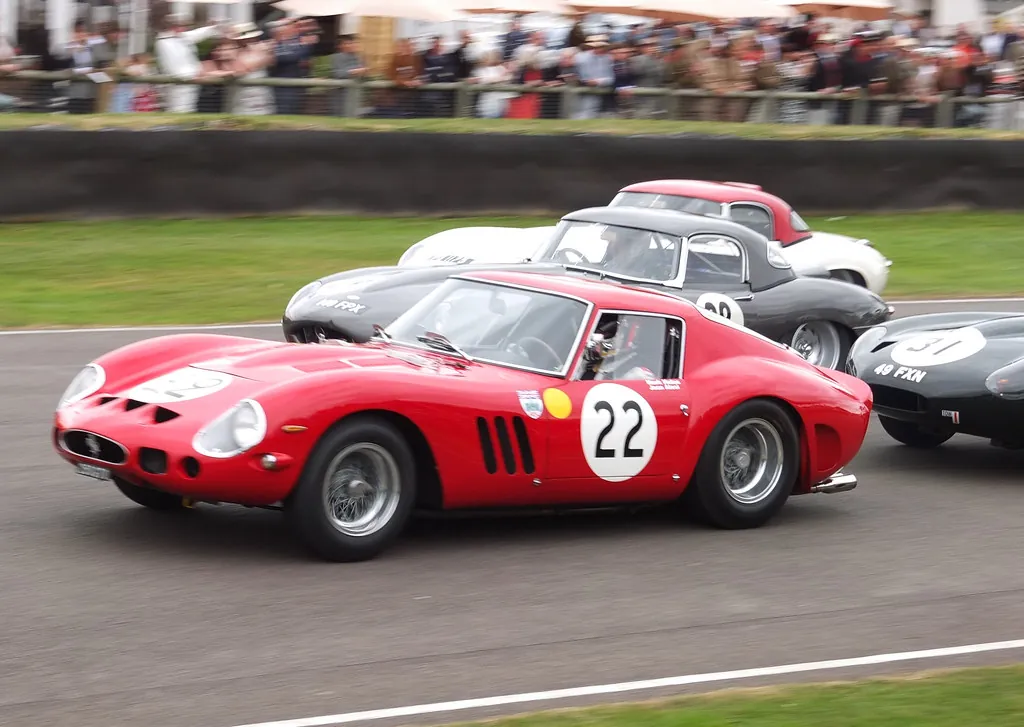 Un Ferrari clásico compitiendo a toda velocidad en un circuito histórico